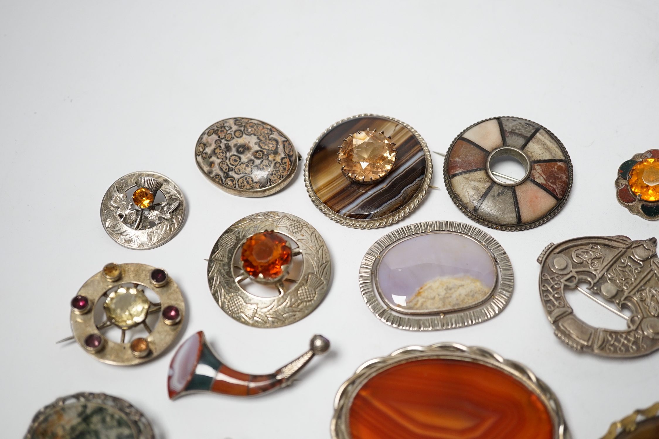 A small collection of mainly silver, sterling and white metal jewellery including Celtic brooches, Iona ship brooch, a Scottish hardstone set bugle brooch and other moss agate set and banded agate set items, largest broo